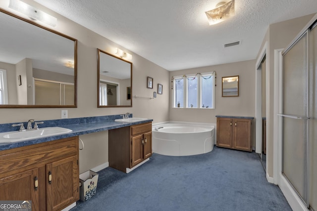 bathroom featuring independent shower and bath, vanity, and a textured ceiling