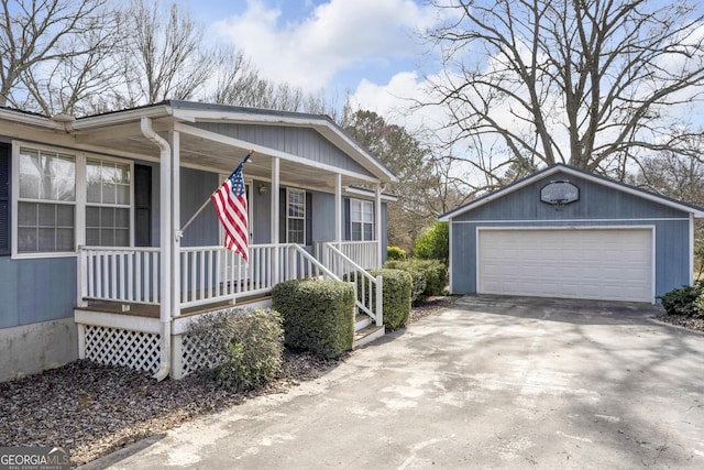 view of front of house with a porch, a garage, and an outbuilding