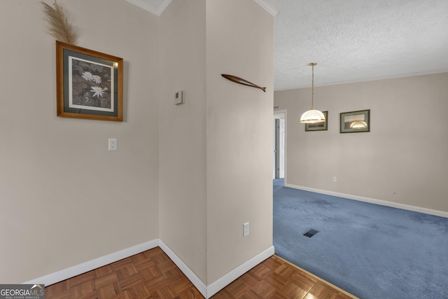 unfurnished room featuring a textured ceiling and dark parquet floors