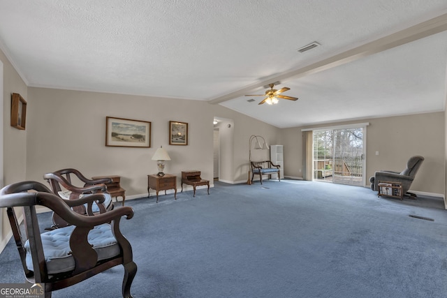 sitting room with a textured ceiling, ceiling fan, carpet flooring, and lofted ceiling with beams