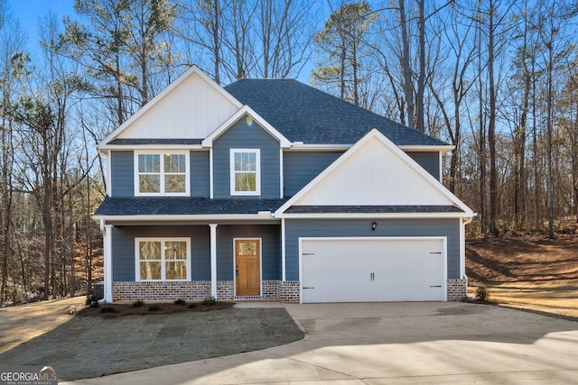 craftsman-style home featuring driveway, roof with shingles, an attached garage, board and batten siding, and brick siding