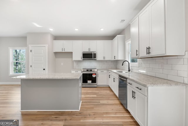 kitchen featuring a sink, visible vents, stainless steel appliances, and a wealth of natural light
