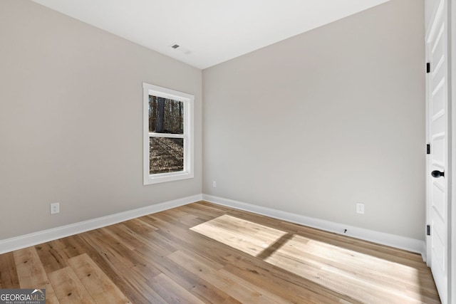 unfurnished room featuring baseboards and light wood-type flooring