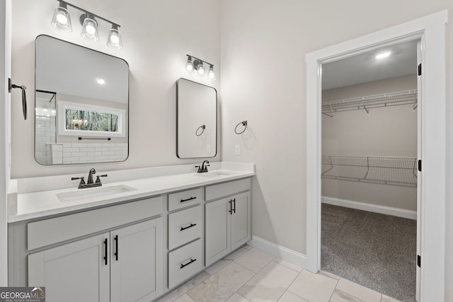 1578 English Rd, Forsyth, GA 31029 - bathroom featuring double vanity, baseboards, a spacious closet, and marble look tiles