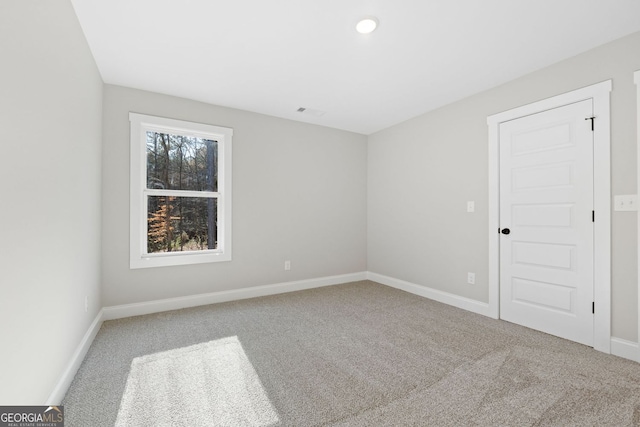 empty room featuring baseboards, carpet, and visible vents