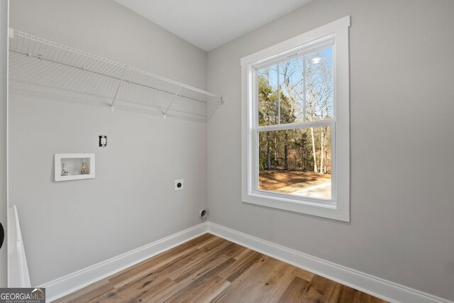 washroom featuring washer hookup, hookup for an electric dryer, laundry area, wood finished floors, and baseboards