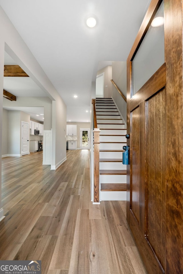 stairway featuring recessed lighting, baseboards, and wood finished floors