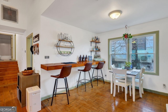 dining space with parquet floors and indoor bar