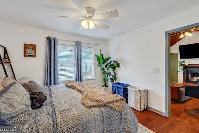 bedroom with dark hardwood / wood-style flooring and ceiling fan