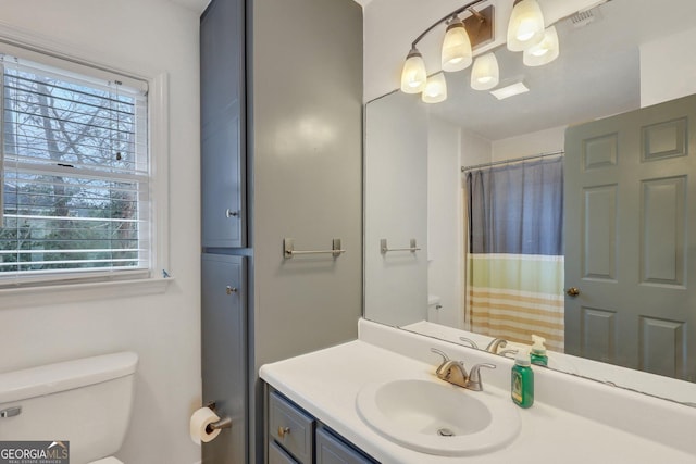 bathroom with toilet, vanity, and a shower with curtain