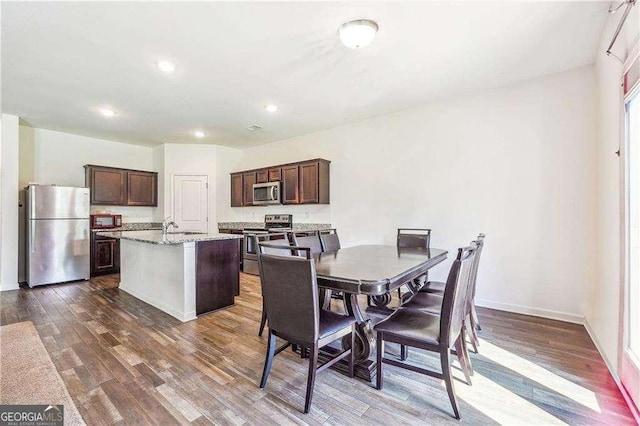 dining room with dark hardwood / wood-style flooring and sink