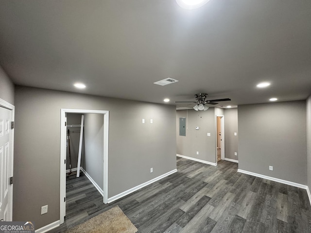 unfurnished room with electric panel, ceiling fan, and dark hardwood / wood-style floors