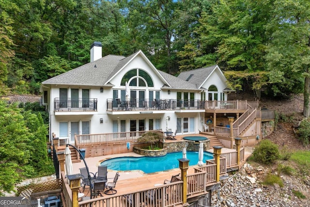 back of property featuring a patio area, a chimney, a wooden deck, and stairs