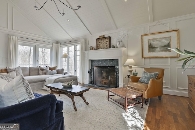 living room with a high end fireplace, dark wood-type flooring, french doors, wood ceiling, and beamed ceiling