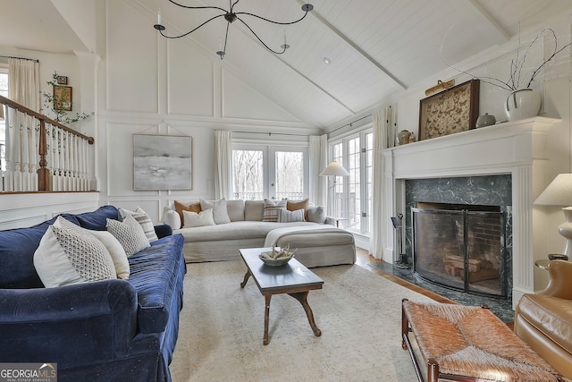 living room featuring beam ceiling, french doors, high vaulted ceiling, wood ceiling, and a fireplace