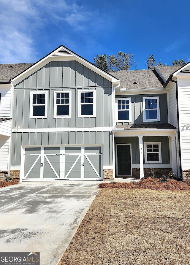 view of front of property featuring driveway, a shingled roof, and board and batten siding