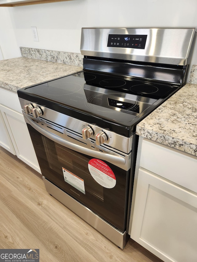 26 Russet Way Lot 61, Newnan, GA 30263 - kitchen view of stainless steel electric range oven, light wood-style floors, white cabinets, and light countertops