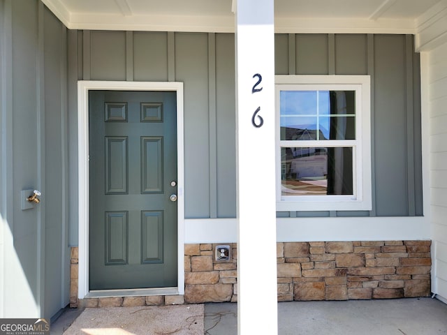 doorway to property with stone siding and board and batten siding