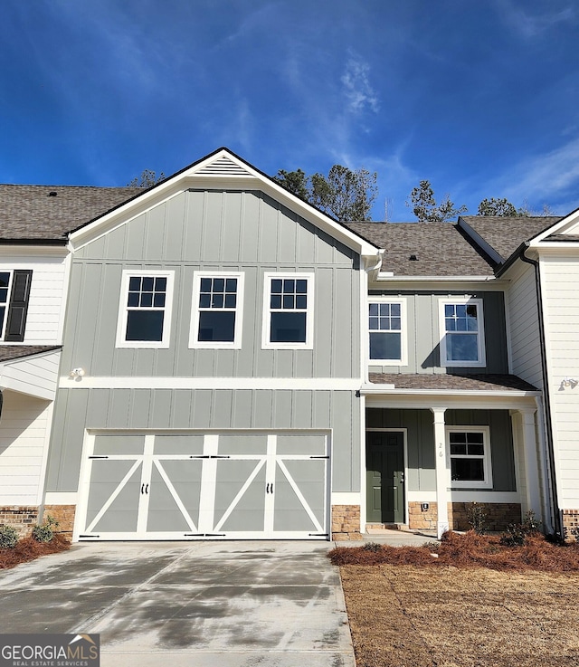 view of front of house with a garage, concrete driveway, a shingled roof, and board and batten siding