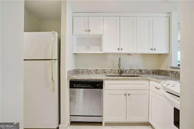 kitchen featuring white appliances, sink, white cabinets, and light stone countertops