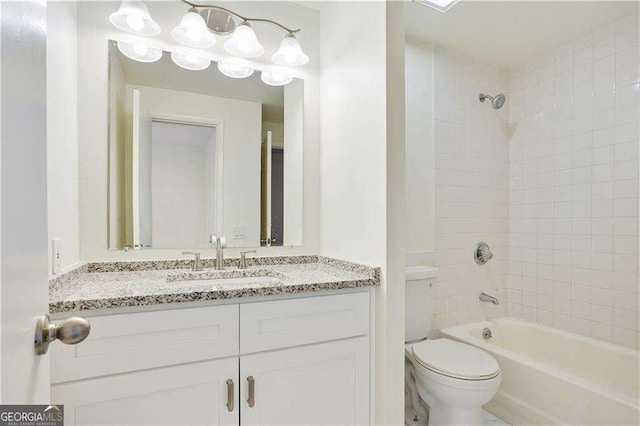 full bathroom featuring tiled shower / bath combo, vanity, and toilet