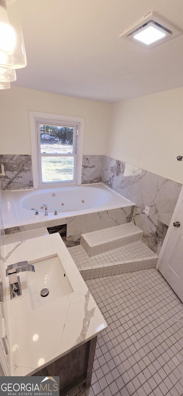 bathroom featuring sink, tile patterned floors, and tiled bath