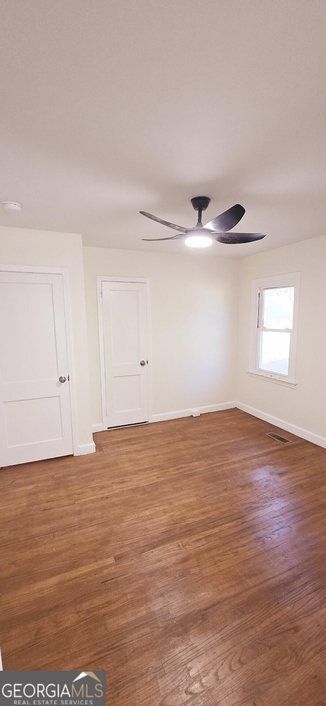 spare room with ceiling fan and wood-type flooring