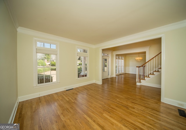 interior space with hardwood / wood-style flooring, crown molding, and an inviting chandelier