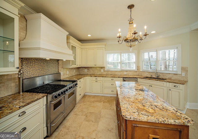 kitchen with sink, custom exhaust hood, pendant lighting, crown molding, and range with two ovens