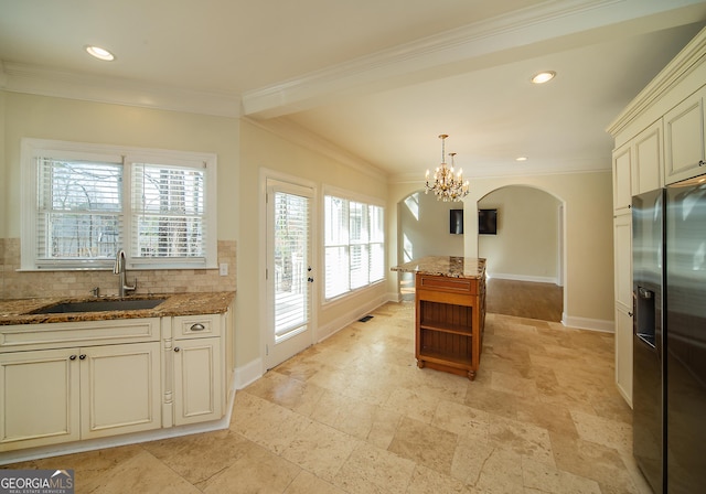 kitchen featuring decorative light fixtures, decorative backsplash, sink, and stainless steel fridge with ice dispenser