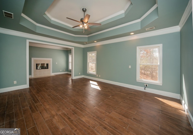 unfurnished living room featuring a premium fireplace, dark wood-type flooring, crown molding, and a raised ceiling