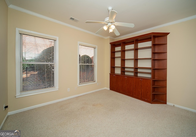 empty room featuring ceiling fan, ornamental molding, and light carpet