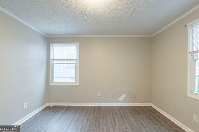 empty room with dark wood-type flooring, ornamental molding, a textured ceiling, and baseboards