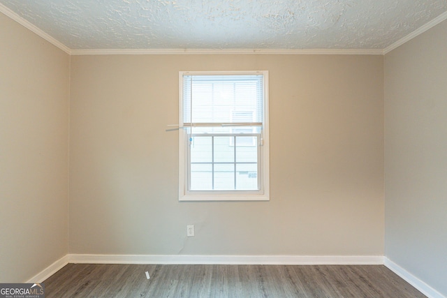 spare room featuring plenty of natural light, wood finished floors, and baseboards