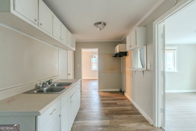 kitchen featuring a wealth of natural light, white cabinetry, light countertops, and a sink