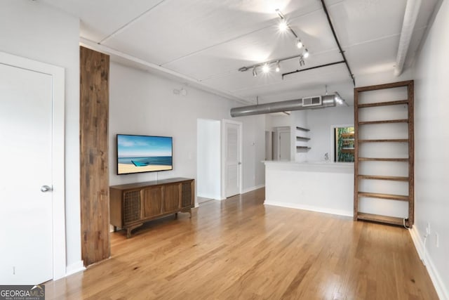 unfurnished living room with track lighting and hardwood / wood-style flooring