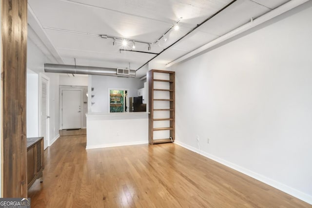 interior space with rail lighting and light hardwood / wood-style floors