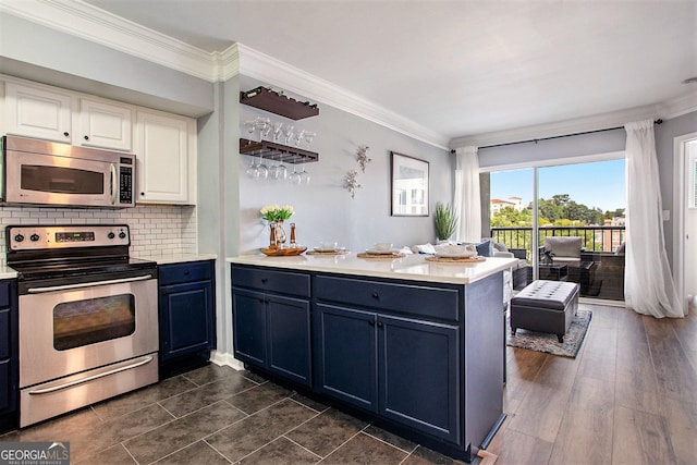 kitchen with white cabinets, crown molding, stainless steel appliances, and kitchen peninsula