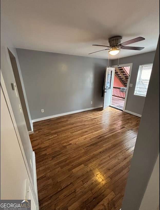 spare room with ceiling fan and dark hardwood / wood-style flooring