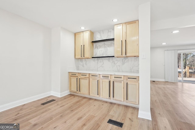 kitchen with tasteful backsplash, light countertops, visible vents, and light brown cabinetry