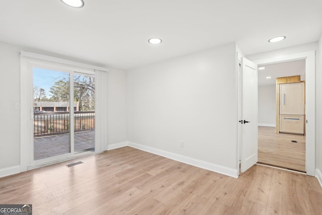 spare room with light wood-type flooring, baseboards, visible vents, and recessed lighting