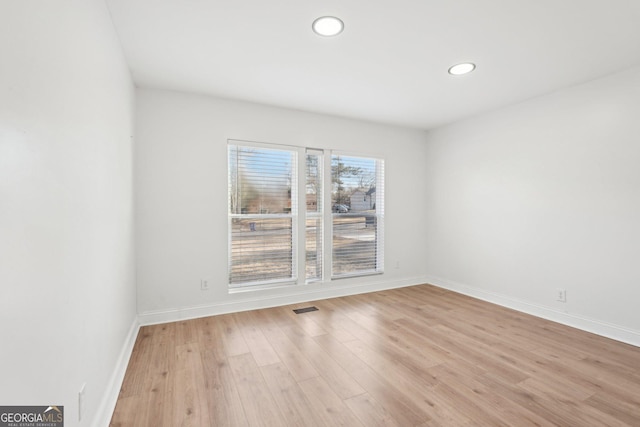 spare room with recessed lighting, light wood-type flooring, visible vents, and baseboards