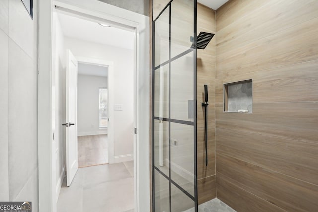 bathroom with a stall shower and baseboards