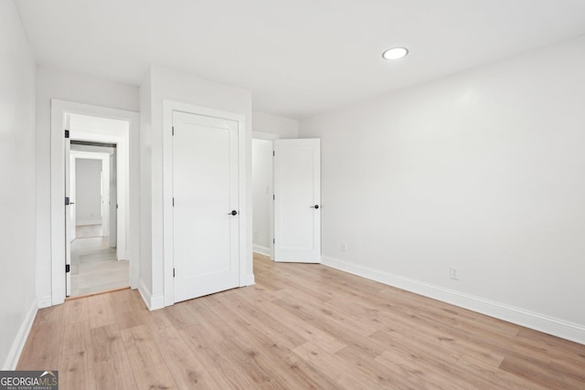 unfurnished bedroom featuring light wood finished floors, recessed lighting, and baseboards