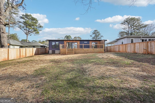 back of property with a fenced backyard and a yard