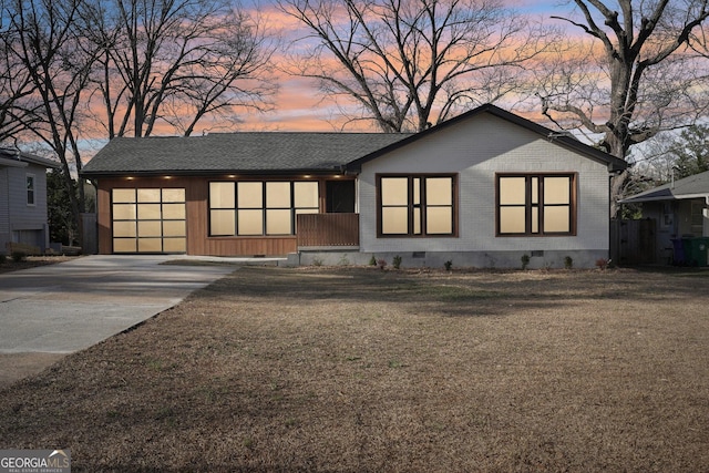 view of front of house featuring brick siding, concrete driveway, roof with shingles, crawl space, and a front yard