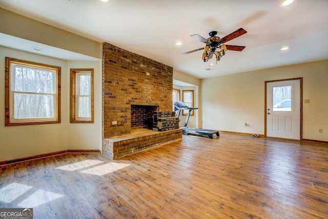 unfurnished living room featuring a fireplace, hardwood / wood-style floors, and ceiling fan