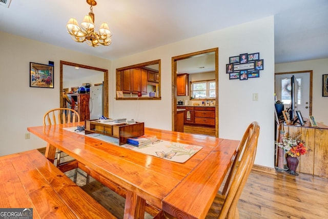 dining area with a notable chandelier and light wood-type flooring