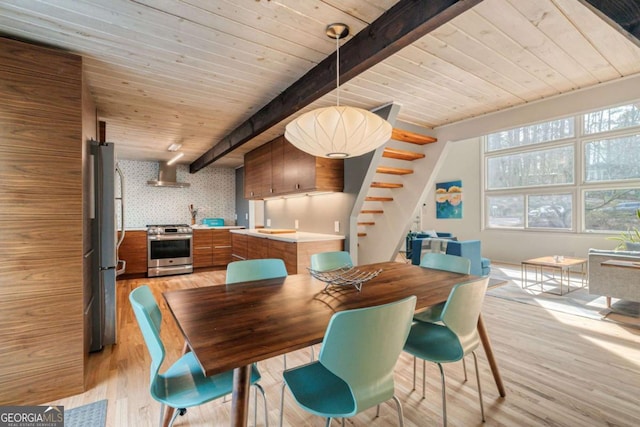 dining space with beam ceiling, wood ceiling, light wood finished floors, and stairs