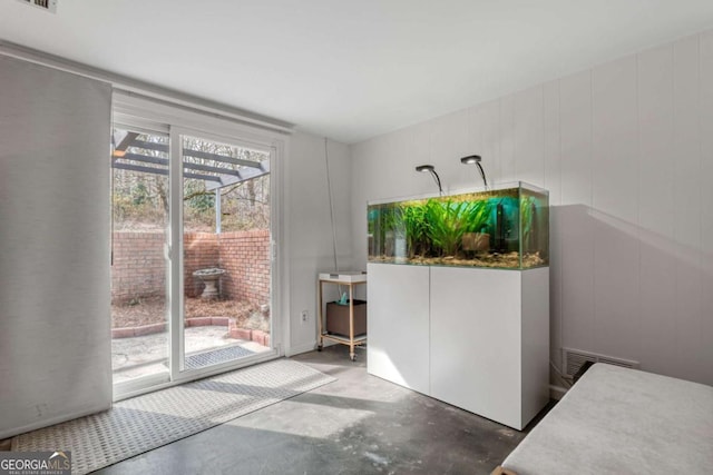 doorway to outside featuring visible vents and concrete floors